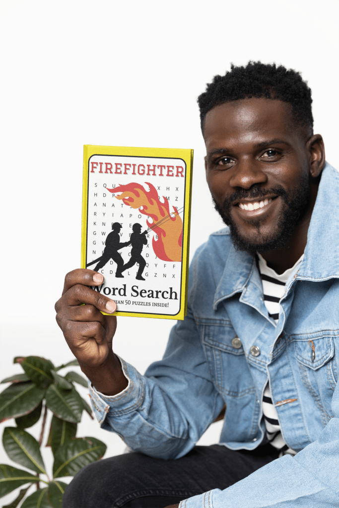 A man holds up a Firefighter Word Search Book with a big smile on his face.